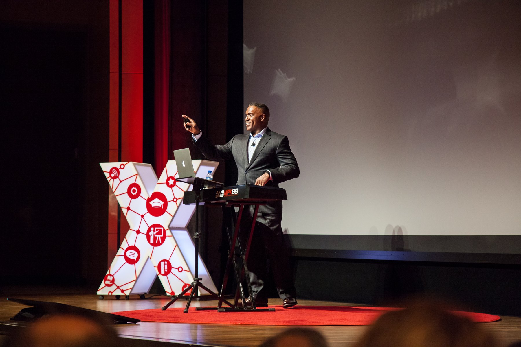 Dr. Darryl S. Adams speaking at TEDx behind an Akai keyboard